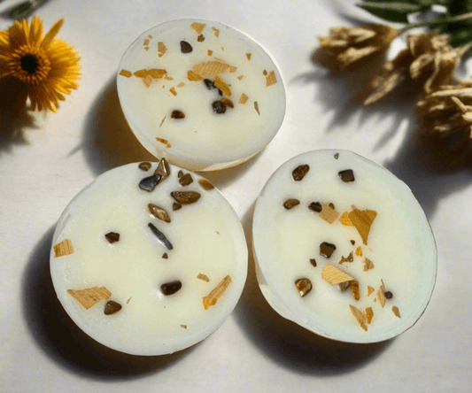 Handmade Sea Salt & Cocoa Bean infused spell melts with herbs and crystals, arranged with natural flowers.